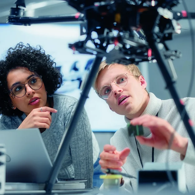1449084409 Two Diverse Developers Brainstorming and Programming. Working Together on a New Drone. Colleagues Building, Configuring and Testing Machines. Progressive Technologies Concept.